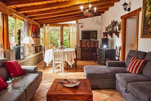 a living room with two couches and a table at Finca OASIS Fataga in Maspalomas