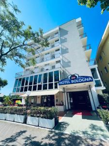 a hotel building with a hotel sign in front of it at Hotel Bologna in Misano Adriatico