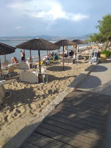 a beach with chairs and umbrellas and people on it at Archontiko-Peraia-Thessaloniki-Airport in Perea