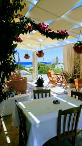 a white table with chairs and flowers on a patio at Aegean Star Hotel in Karavostasi