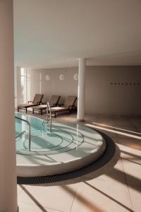 a large glass hot tub in a room with chairs at Strandhotel Ostseeblick in Heringsdorf