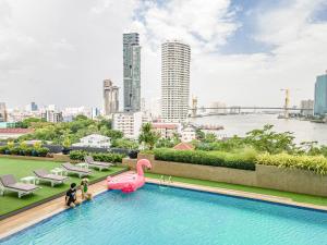 a swimming pool with a pink flamingo in a city at Montien Riverside Hotel Bangkok in Bangkok