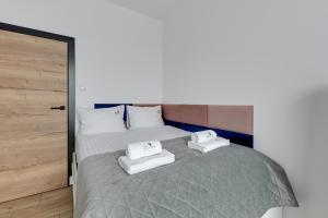 a bedroom with a bed with two towels on it at Botanica Prestige - 2 sypialnie, parking w Jelitkowie by Lion Apartments in Gdańsk
