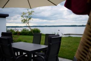 una mesa y sillas con vistas al lago en Traumhaus mit Fördeblick - FÖRDE-ANKER, en Glücksburg