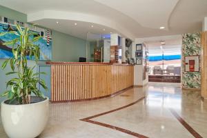 a hospital lobby with a potted plant in the middle at Apartamentos las Góndolas in Playa del Ingles