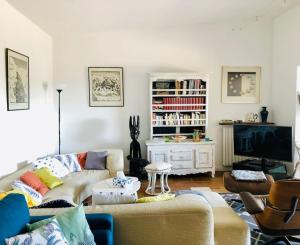 een woonkamer met een bank en een tv bij Villa-Golfe de Saint-Tropez/Accès plage privée in Grimaud