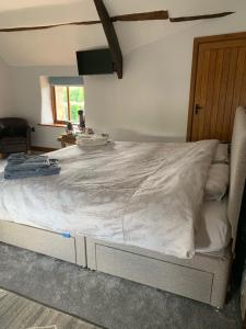 1 cama blanca grande en una habitación con ventana en Gooseford Farm en Okehampton