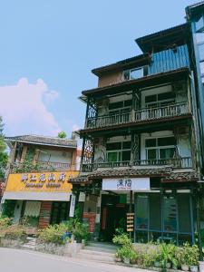 un ancien bâtiment avec un balcon dans une rue dans l'établissement Yangshuo Xingping This Old Place Li-River Inn, à Yangshuo