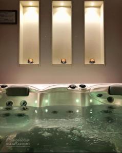 un lavandino in bagno con quattro specchi di Spa Pleasure Apartman a Novi Sad