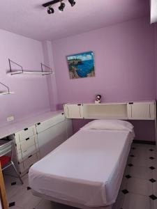 - une petite chambre avec un lit et un bureau dans l'établissement Apartamentos Casa May III - Centro Benidorm, à Benidorm