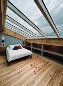 - une chambre avec un lit et une grande fenêtre dans l'établissement LOFT et SPA sous les étoiles, à Foix