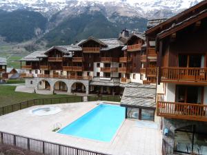 un complejo con piscina frente a una montaña en Appartement Lanslebourg-Mont-Cenis, 2 pièces, 4 personnes - FR-1-508-251, en Lanslebourg-Mont-Cenis