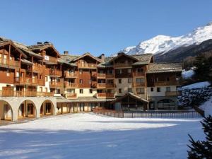 a large apartment building in the mountains with snow at Appartement 4 pers. pied des pistes avec piscine et parking, Lanslebourg-Val Cenis - FR-1-508-251 in Lanslebourg-Mont-Cenis