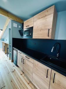 a kitchen with wooden cabinets and a microwave at LOFT et SPA sous les étoiles in Foix