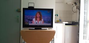 a television sitting on top of a wooden dresser at Studio de 12m² agréable calme proche CHU in Dijon