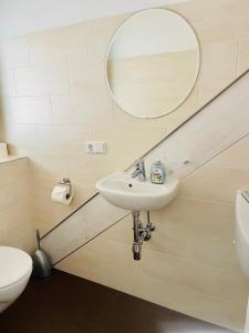 uma casa de banho com um lavatório e um espelho em Apartments Sunny Place em Rust
