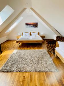 a attic bedroom with a bed and a rug at Apartments Sunny Place in Rust