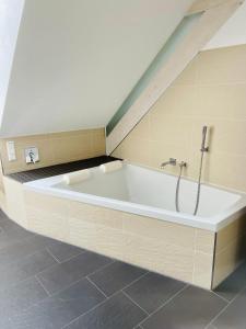a white bath tub in a room with a ceiling at Apartments Sunny Place in Rust