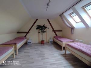 a room with three beds in a attic at Ubytování Naděje in Klec