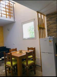 eine Küche mit einem Holztisch und einem Kühlschrank in der Unterkunft Vikendica Morinj in Donji Morinj