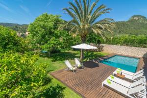 - une terrasse avec des chaises et un parasol à côté de la piscine dans l'établissement Can Cabrit, à Alaró