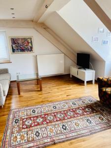 a living room with a rug on a wooden floor at Apartments Sunny Place in Rust