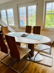 een tafel en stoelen in een kamer met ramen bij Apartments Sunny Place in Rust