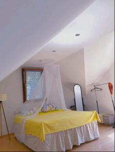 a bedroom with a yellow bed with a mosquito net at Vikendica Morinj in Donji Morinj
