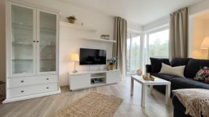 ein Wohnzimmer mit einem Sofa und einem TV in der Unterkunft Strandhaus Nordseebrandung Fewo B1.3 in Cuxhaven