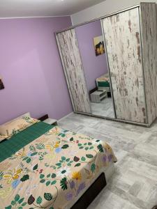 a bedroom with a bed and a large mirror at Casa Lucas si Rafael in 2 Mai