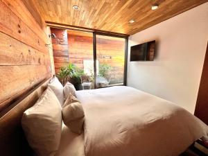 um quarto com uma cama com almofadas e uma janela em maison de stuffmarket em Takamatsu