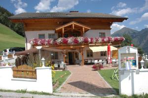 uma casa com uma varanda com flores em Hotel-Pension Lackenbauer em Bad Hofgastein