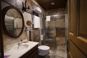 a bathroom with a sink and a toilet and a mirror at Foleya Mountain Resort Hotel & Villas in Trabzon