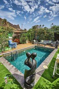 a pool with a statue in the middle of a yard at Finca OASIS Fataga in Maspalomas