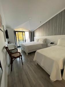 una habitación de hotel con 2 camas y una silla en Burla Han en Urla