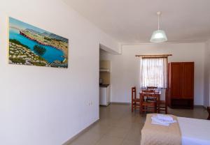 a living room with a table and a kitchen at Sifis Studios in Palaiochora