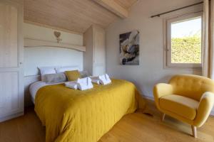 a bedroom with a yellow bed and a chair at Chalet Taninges in Taninges