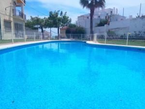 a swimming pool with blue water at Mediterraneo Carihuela - Torremolinos in Torremolinos