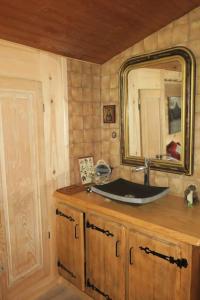 uma casa de banho com um lavatório e um espelho em chez Lily em Samoëns