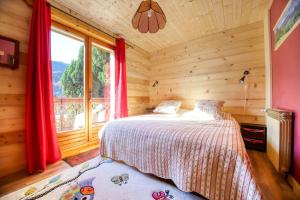 um quarto com uma cama e uma grande janela em chez Lily em Samoëns