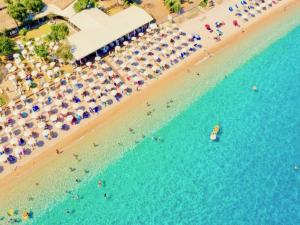 een uitzicht over een strand met mensen en parasols bij Barbati Blu & Verde Beach Houses with pool by DadoVillas in Barbati