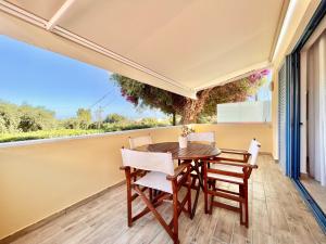 een eetkamer met een tafel en stoelen op een balkon bij Barbati Blu & Verde Beach Houses with pool by DadoVillas in Barbati