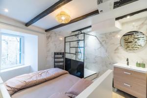 - une chambre avec un lit et un miroir dans l'établissement Logement Duplex au cœur de Tréguier, à Tréguier