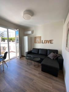 ein Wohnzimmer mit einer schwarzen Couch und einem Tisch in der Unterkunft Apartamentos San Miguel in Torremolinos