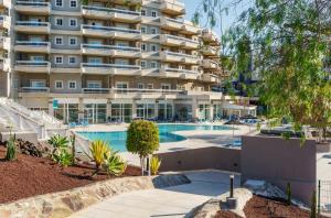 a large apartment building with a swimming pool at Alua Atlantico Golf - All Inclusive in San Miguel de Abona