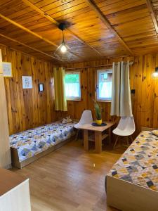 a room with two beds and a table and chairs at Campus Karolina in Brenno