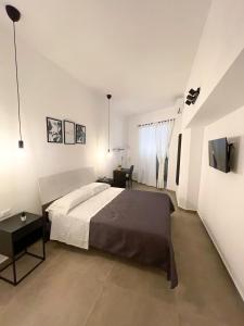 een slaapkamer met een bed, een bureau en een televisie bij DonPè in Agrigento