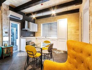 Żurrieq的住宿－Nigret Step’n’Suites，厨房配有桌子和黄色椅子