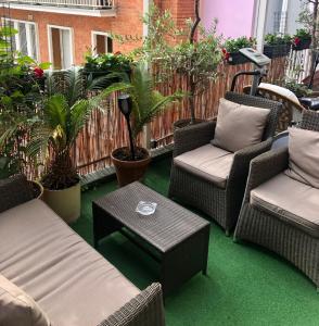 een patio met stoelen, een tafel en planten bij Hôtel Poussin in Parijs