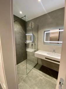a bathroom with a glass shower and a sink at Hotel President in Shëngjin